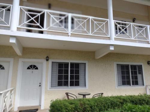 a building with a balcony with a table and chairs at Club Caribbean Apartments in Runaway Bay