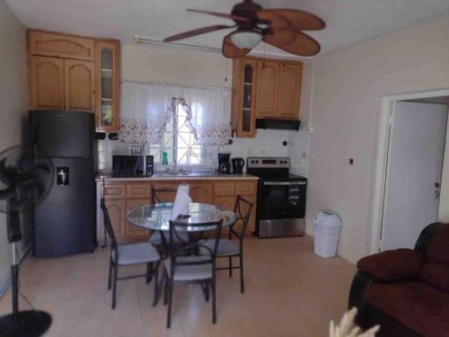 a kitchen with a table and chairs and a ceiling fan at Club Caribbean Apartments in Runaway Bay