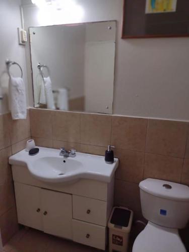 a bathroom with a sink and a toilet and a mirror at Club Caribbean Apartments in Runaway Bay