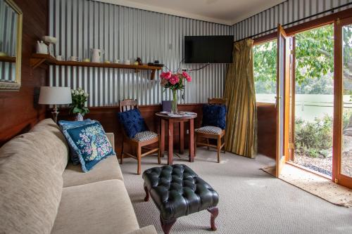 a living room with a couch and a table at Riverlea Cottage in Apple Tree Flat