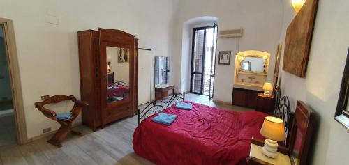 a bedroom with a red bed and a large mirror at Classy central apartment in Bari