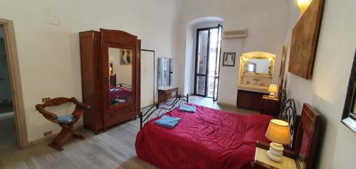 1 dormitorio con cama roja y espejo grande en Very central apartment, by shops, bars, restaurants, en Bari