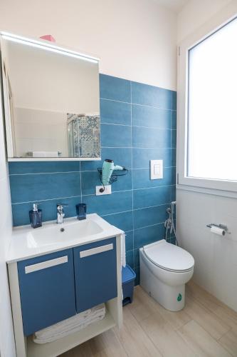 a bathroom with a sink and a toilet and a mirror at MARE e Terra Holiday fronte mare in San Vito lo Capo