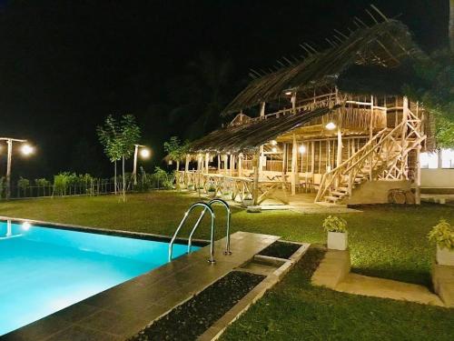 a resort with a swimming pool at night at Tea Garden Eco Villas in Morawaka