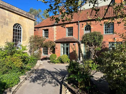 an old brick house with a driveway in front of it at Kylemore in Glastonbury