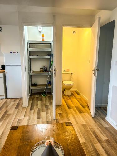 La salle de bains est pourvue de toilettes et d'une porte jaune. dans l'établissement Chaleureux T2 meublé 5mn Alençon, à Cuissai