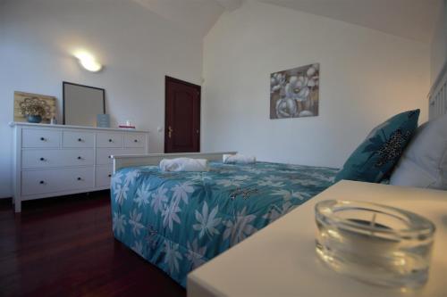 a bedroom with a bed and a dresser at Rose Velvet in Angra do Heroísmo