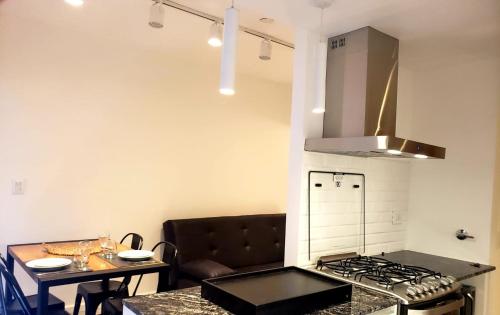 cocina con fogones horno superior junto a una mesa en departamento luminoso y centrico en Mar del Plata