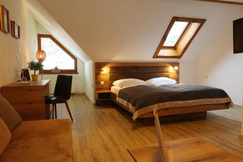 a bedroom with a bed and a desk and a couch at Vila Edelweiss Rooms&App Kranjska Gora in Kranjska Gora