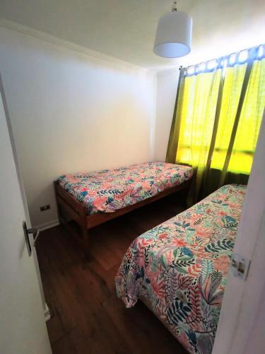 a small room with two beds and a window at Departamento Portal del Norte 1 in Arica