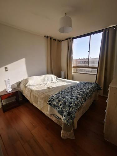 a bedroom with a bed and a large window at Departamento Portal del Norte 1 in Arica