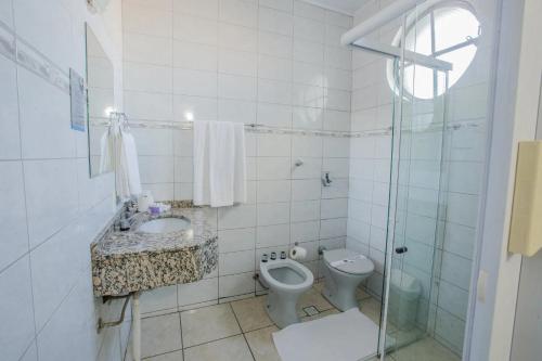 a bathroom with a toilet and a sink and a shower at Foz Presidente Economic Hotel in Foz do Iguaçu