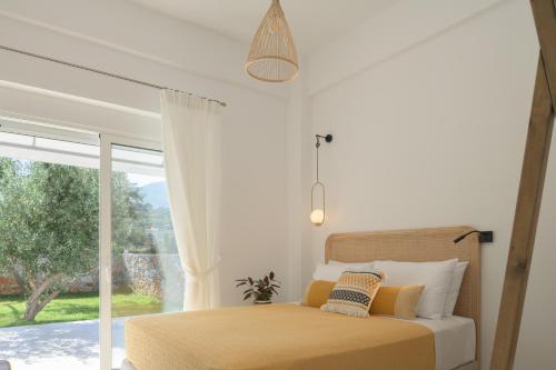 una camera con un letto e una grande finestra di pelagias villa lefka with heated pool a Mathés