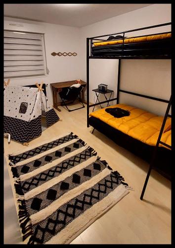 - une chambre avec 2 lits superposés et un tapis dans l'établissement La Nomade, à Marckolsheim