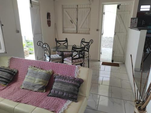 ein Wohnzimmer mit einem Sofa und einem Tisch in der Unterkunft Chez Axel in Le Marin