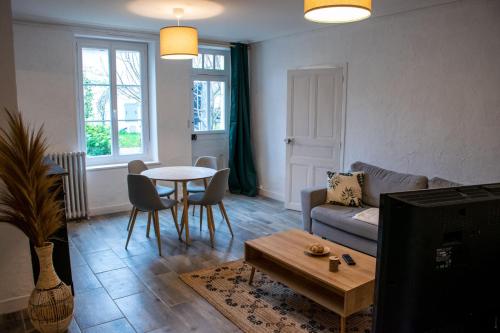 a living room with a couch and a table at Gîte rénové avec piscine au cœur de Vendôme in Vendôme