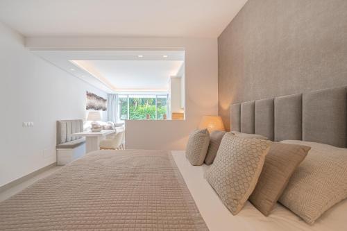 um quarto com uma cama grande e almofadas em Puente Romano Hotel Apartment Marbella em Marbella