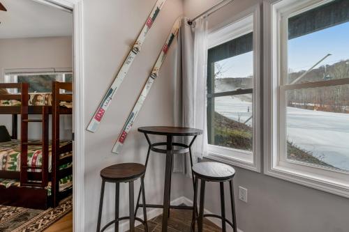 a room with two stools and skis on the wall at Slopesider 08 in Sugar Mountain