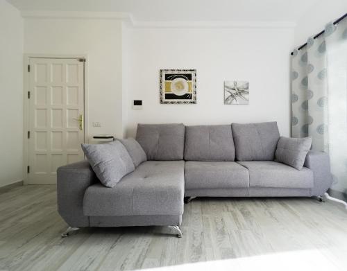 sala de estar con sofá gris frente a una puerta en Casa Came - A/C+ WiFi - 1min Beach, en Arona