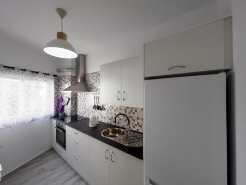 una cocina con armarios blancos y fregadero en Casa Came - A/C+ WiFi - 1min Beach, en Arona