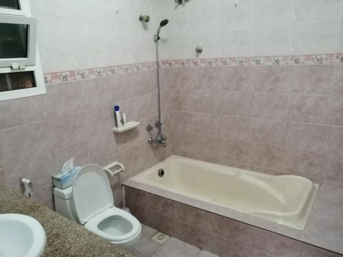 a bathroom with a tub and a toilet and a sink at Muscat Homestay & Hospitality in Muscat