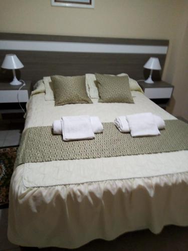 a large bed with towels and pillows on it at Rivera Este in Colón