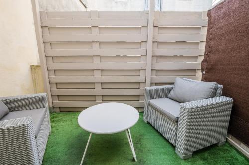 a patio with two chairs and a white table at Studio en Duplex-Aircon-Terrasse-Parking-Calme in Bordeaux