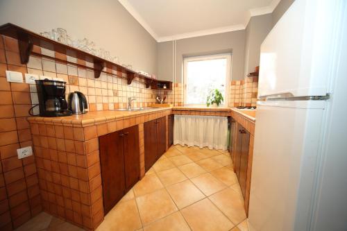 a kitchen with wooden cabinets and a white refrigerator at Vila Edelweiss Rooms&App Kranjska Gora in Kranjska Gora