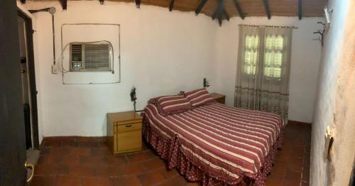 1 dormitorio con cama, espejo y ventana en Paty house en Paso de la Patria