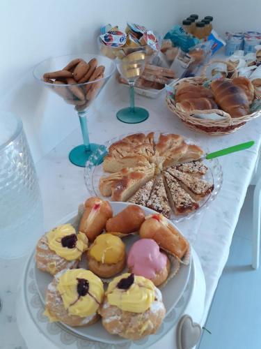 a table topped with plates of pastries and desserts at B&b la Casa dei Nonni in Silvi Paese