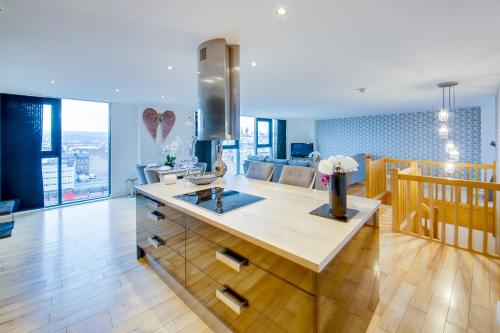 a kitchen with a large island in the middle of a room at Spacious 3-Bed Penthouse with City Sky Line Views in Sheffield