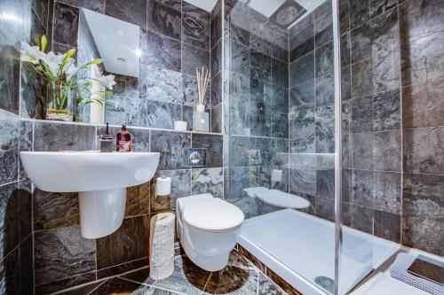 a bathroom with a sink and a toilet and a shower at Spacious 3-Bed Penthouse with City Sky Line Views in Sheffield