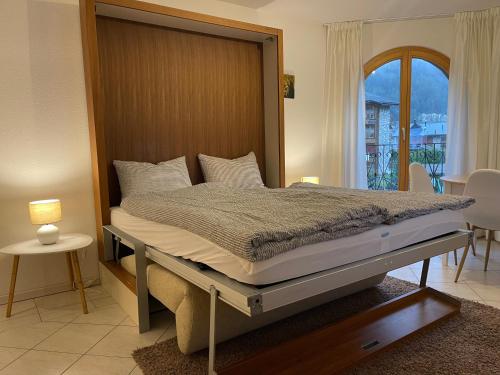 Schlafzimmer mit einem großen Bett mit einem Kopfteil aus Holz in der Unterkunft Chateau Leukerbad in Leukerbad