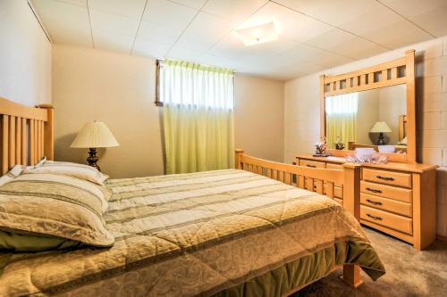 a bedroom with a bed and a dresser and a mirror at Bright Springer House with Hammock and Orchard Views! in Springer