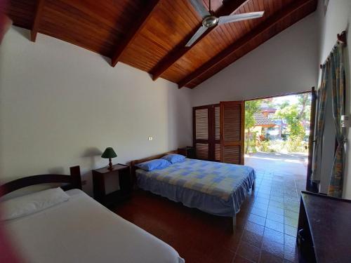 a bedroom with two beds and a ceiling fan at Hotel Las Brisas del Pacifico in Sámara