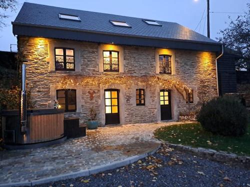 una casa de piedra con luces en la parte delantera en La Maison de Madeleine, en Léglise