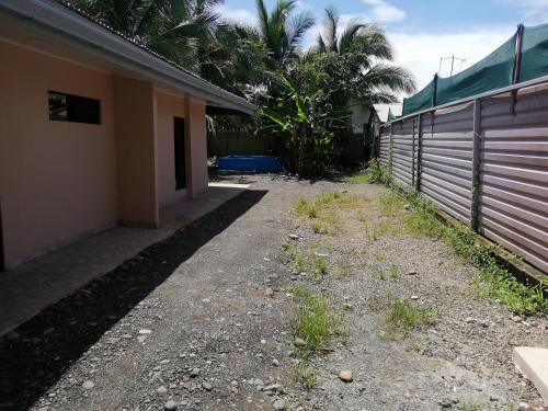 an empty alley next to a house with a fence at Casa début Surf Place in Parrita