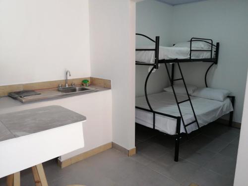 a kitchen with a bunk bed next to a sink at Casa début Surf Place in Parrita