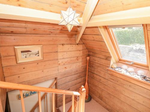 a staircase in a log cabin with a wooden wall at Kipper Lodge in Dartmouth
