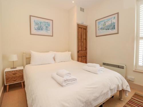 a bedroom with a white bed with towels on it at Kipper Lodge in Dartmouth