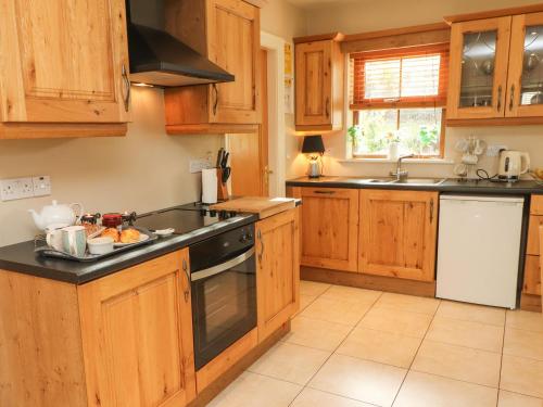 a kitchen with wooden cabinets and a stove top oven at Rocklands House in Beaufort