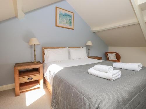 a bedroom with a bed with two white towels on it at Kipper Lodge in Dartmouth
