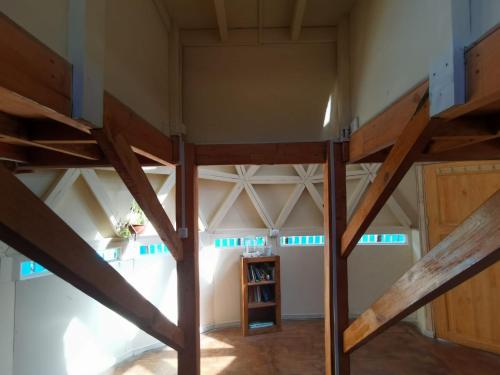 an attic room with a loft bed and wooden beams at Alquimia del Hualle in Melipeuco