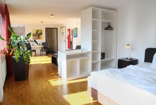 ein Schlafzimmer mit einem Bett und ein Zimmer mit einem Schreibtisch in der Unterkunft SEEGER Living Comfort Downtown in Karlsruhe