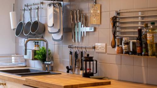 a kitchen with a sink and utensils on the wall at London Bridge 3 Bedroom House with reception room, office and private garden in London