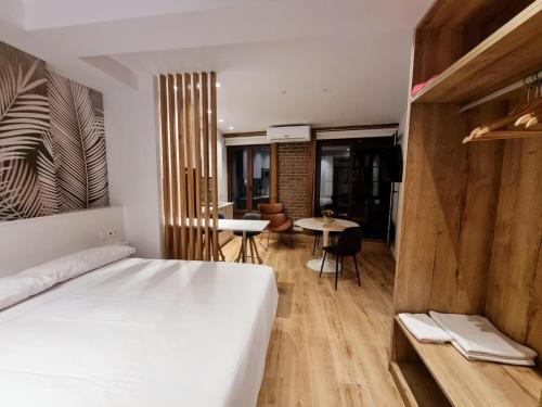 a bedroom with a bed and a table and chairs at Suites BERRUETA (Plaza Mayor) in León