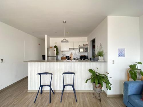 een keuken en een woonkamer met 2 krukken en een aanrecht bij Modern Ocean view Apt. Miraflores Center w/Balcony in Lima