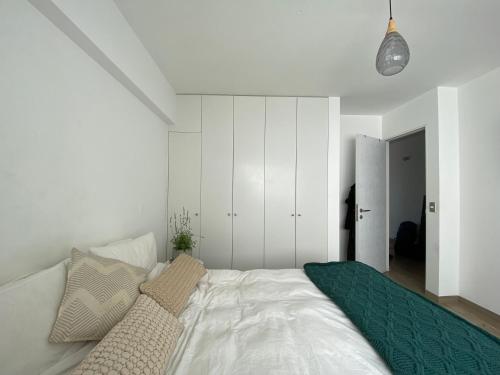 een slaapkamer met een groot wit bed met kussens bij Modern Ocean view Apt. Miraflores Center w/Balcony in Lima