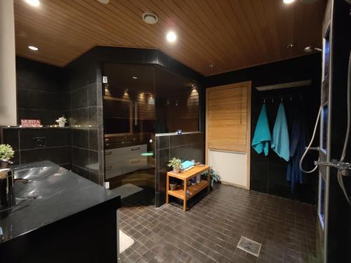 bagno con pareti nere, doccia e tavolo di VillaSki a Rovaniemi