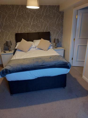 a bedroom with a large bed with two night stands at the noel @ whitwell in Oakham